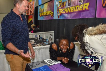 Actors Janeshia Adams-Ginyard and John Schneider share laughs at the 2018 Alaska Comic Con.