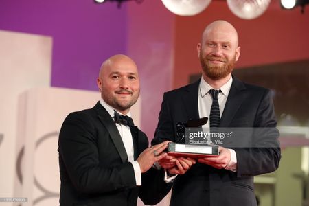VENICE, ITALY - SEPTEMBER 11: Lucas Engel (R) and Adam Butterfield (L) pose with Orizzonti Award for the Best Short Film