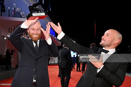 VENICE, ITALY - SEPTEMBER 11: Lucas Engel (L) and Adam Butterfield (R) pose with Orizzonti Award for the Best Short Film