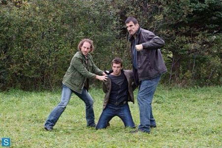Sinister Man (Kyle Mitchell) and Heavy (Robert Maillet) hold Nathan Wuornos (Lucas Bryant) for a beating. Haven TV Show 