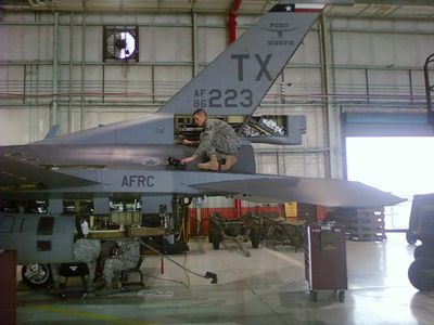 James Burleson is performing a nondestructive inspection testing method on the exterior of an F-16.