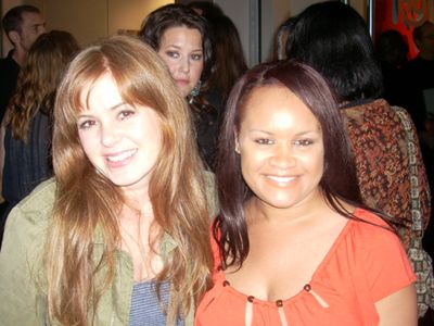Stacy Arnell and Isla Fisher posing for photos at an art show in Beverly Hills, CA