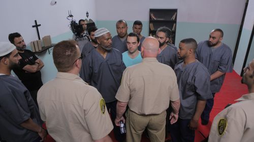 A tense scene between Middle Eastern inmates and prison guards directed by Aziz Tazi.