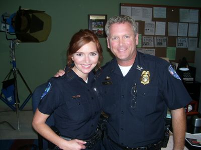 Tony Senzamici as Police Chief Stites with Brigid Brannagh as Officer Pamela Moran on the set of Army Wives. Episode 513