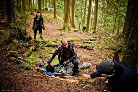 Mairzee Almas directs Marie Avgeropoulos and Ricky Whittle on the set of 