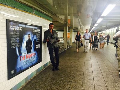 Writer/Director Giovanni Zelko in Grand Central Terminal NYC next to a billboard for his film THE ALGERIAN