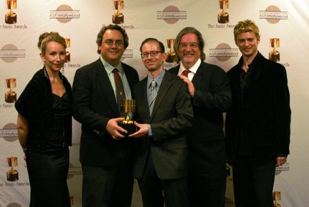 Presenters Jennifer Taylor Lawrence and Crispin Freeman flank Best Home Entertainment Production winners Peter Avanzino,